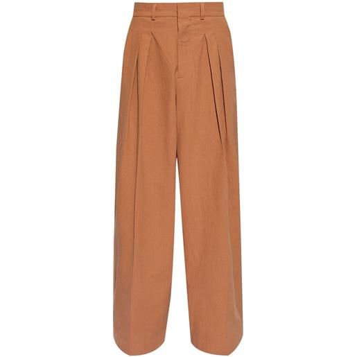 Nanushka pantaloni a gamba ampia con pieghe - arancione